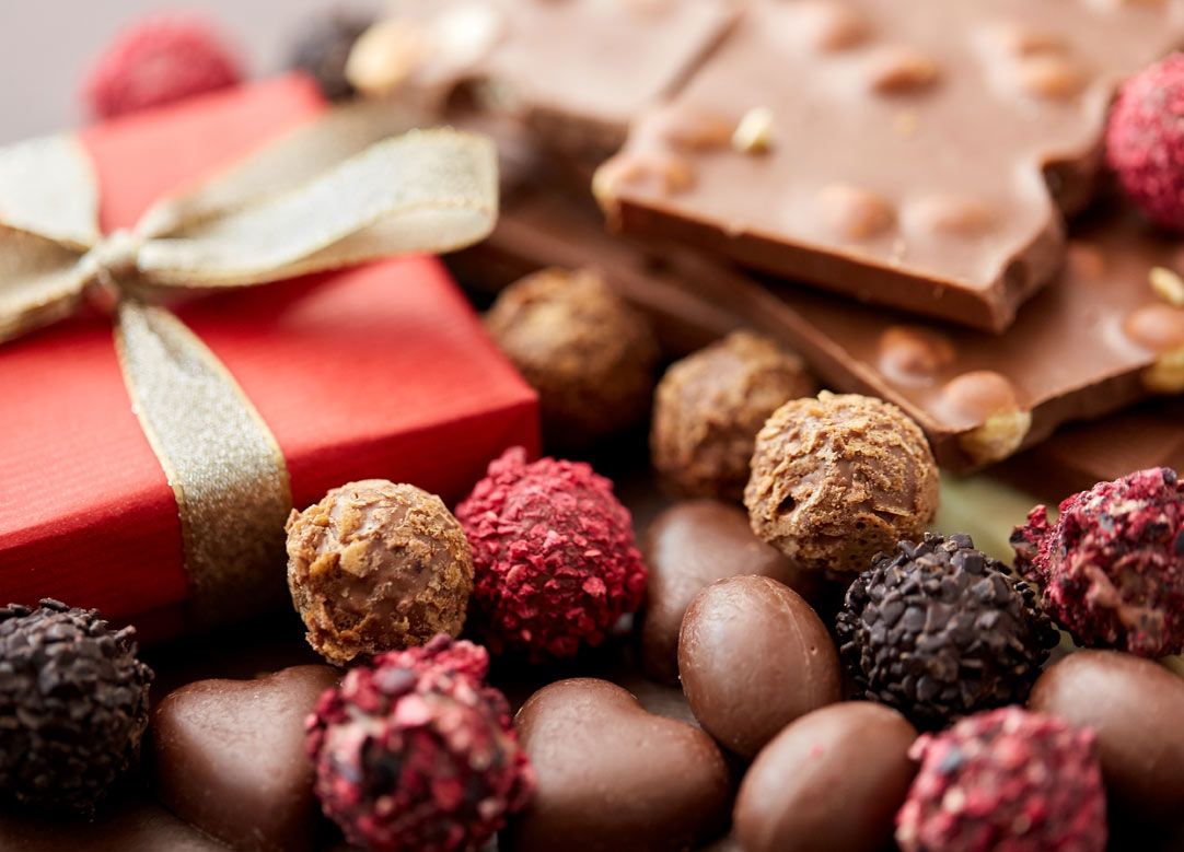 Pralinenpackung mit ausgepackten Pralinen im Vordergrund